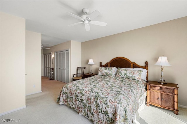 bedroom with ceiling fan, light carpet, and a closet