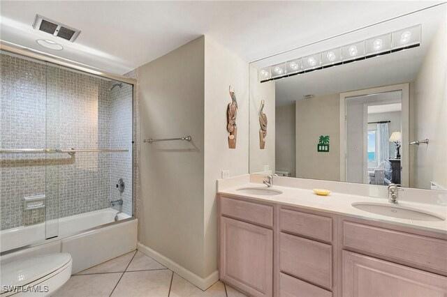 full bathroom featuring combined bath / shower with glass door, vanity, tile patterned flooring, and toilet