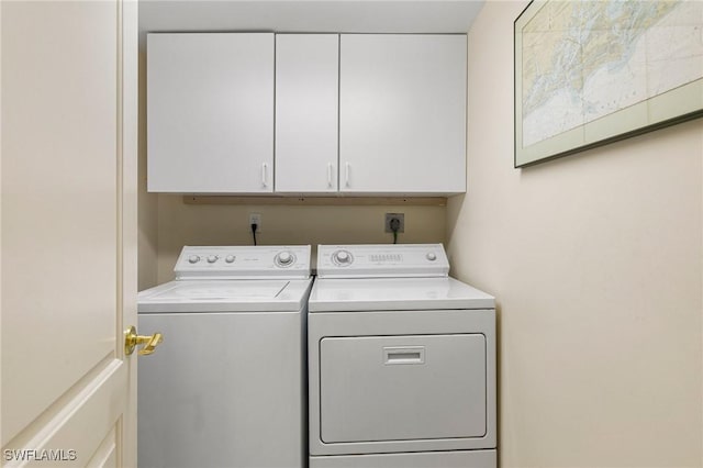 washroom featuring separate washer and dryer and cabinets