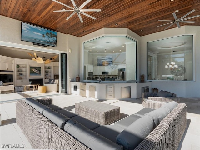 view of patio / terrace with lofted ceiling, a large fireplace, ceiling fan with notable chandelier, and wooden ceiling