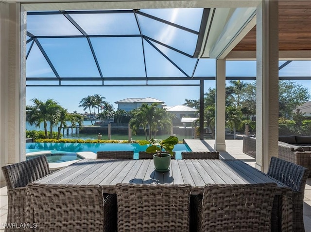 view of patio with a lanai, outdoor lounge area, and a water view