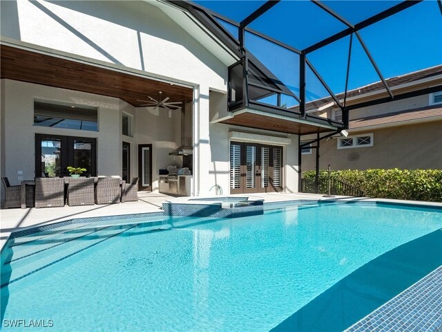 view of swimming pool featuring ceiling fan, a lanai, french doors, and a patio area