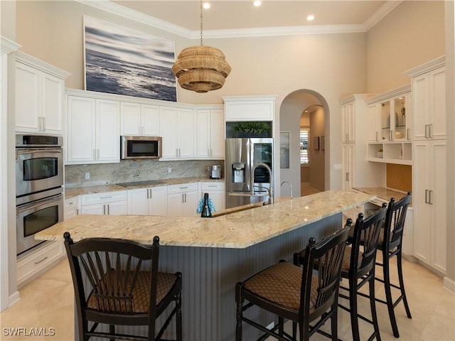 kitchen with stainless steel appliances, a large island, white cabinets, and a kitchen breakfast bar