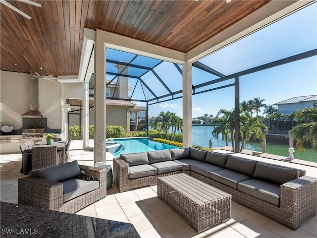 view of patio / terrace featuring an outdoor hangout area, a water view, a lanai, area for grilling, and exterior kitchen