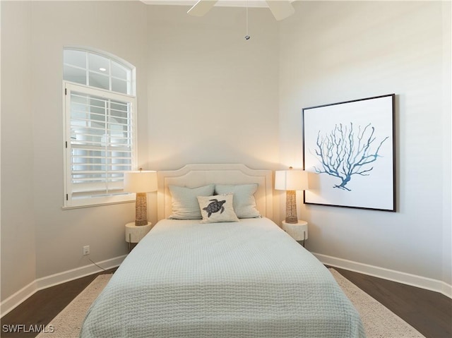 bedroom with dark hardwood / wood-style flooring and ceiling fan