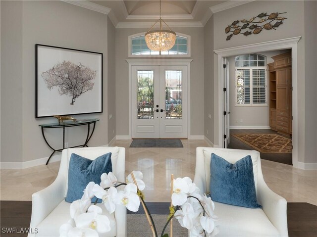 entryway featuring a towering ceiling, french doors, a chandelier, and crown molding