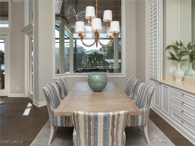 dining area with dark hardwood / wood-style flooring and an inviting chandelier