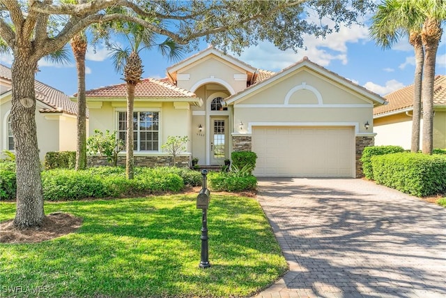 mediterranean / spanish-style house featuring a garage and a front yard