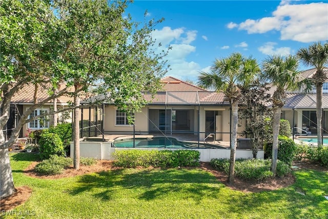 back of house with a yard and a lanai