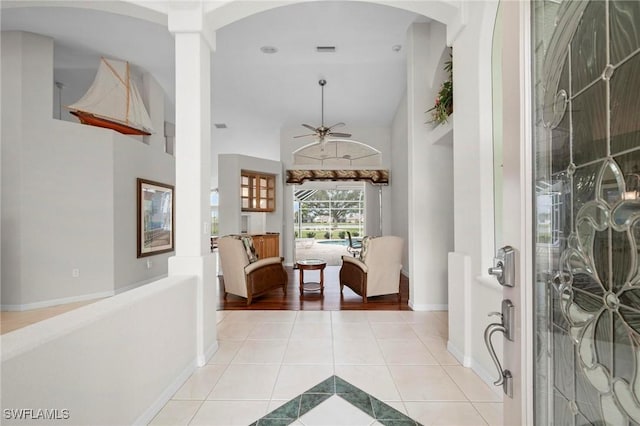 hallway with light tile patterned floors and decorative columns