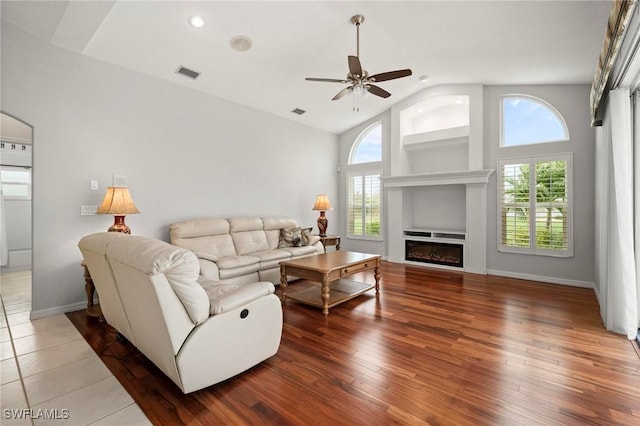 living room with hardwood / wood-style floors, ceiling fan, high vaulted ceiling, and a wealth of natural light