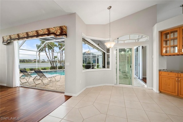 doorway featuring lofted ceiling and light tile patterned flooring