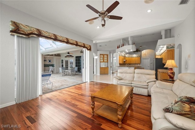 living room featuring wood-type flooring and high vaulted ceiling