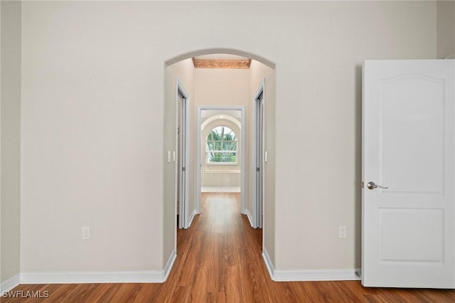 corridor with hardwood / wood-style flooring