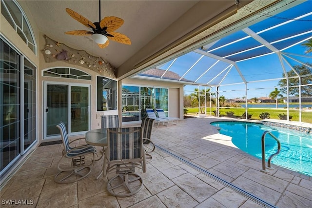 view of swimming pool featuring glass enclosure, ceiling fan, and a patio