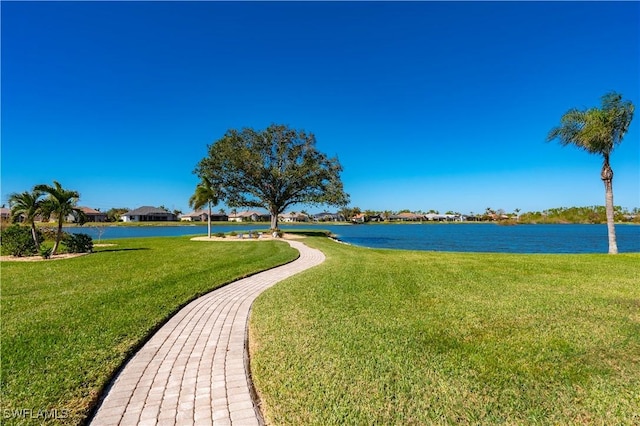 view of home's community featuring a lawn and a water view