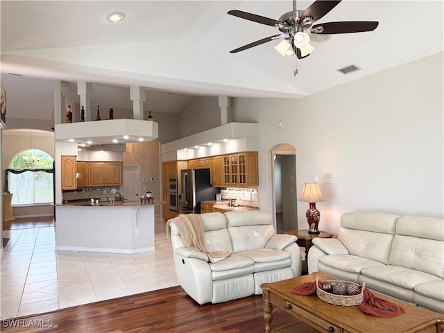 13028 Kingsway Cir SW, Lake Suzy, FL 34269 - living room featuring ceiling fan, high vaulted ceiling, light tile patterned flooring, arched walkways, and recessed lighting