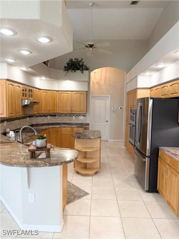 13028 Kingsway Cir SW, Lake Suzy, FL 34269 - kitchen with stainless steel appliances, a peninsula, tasteful backsplash, ceiling fan, and under cabinet range hood