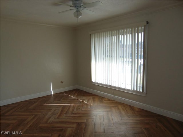 spare room with ceiling fan, dark parquet flooring, and crown molding