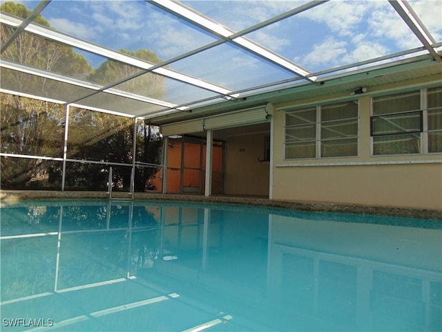 view of pool featuring glass enclosure