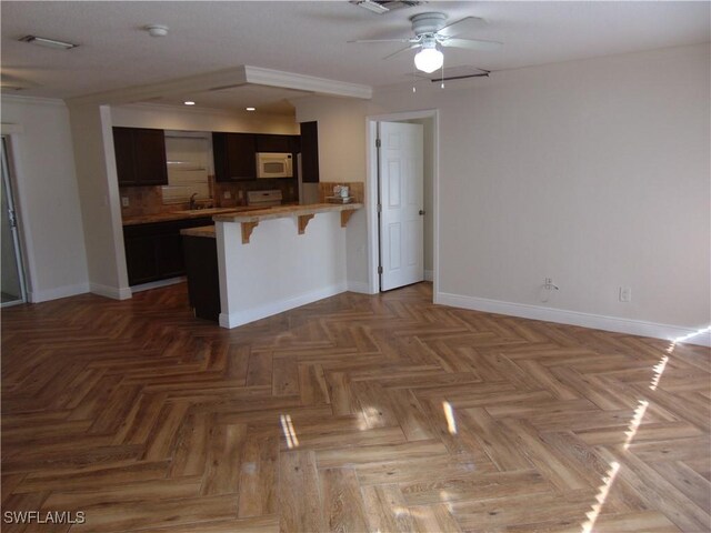 kitchen featuring a kitchen breakfast bar, kitchen peninsula, sink, and light parquet flooring