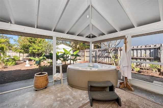 sunroom featuring vaulted ceiling and a hot tub