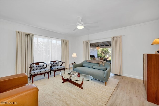 living room with ceiling fan, crown molding, and light wood-type flooring