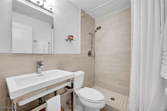 bathroom featuring a tile shower, sink, tasteful backsplash, toilet, and tile walls