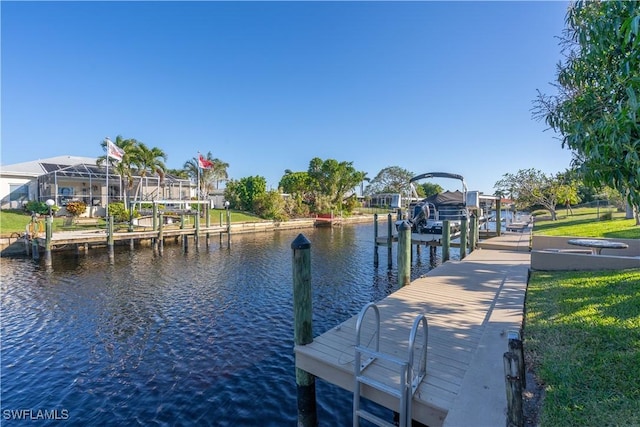 dock area with a lawn and a water view