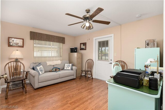 living room featuring ceiling fan and light hardwood / wood-style floors