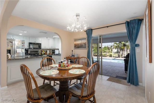 dining room with light tile patterned floors and an inviting chandelier