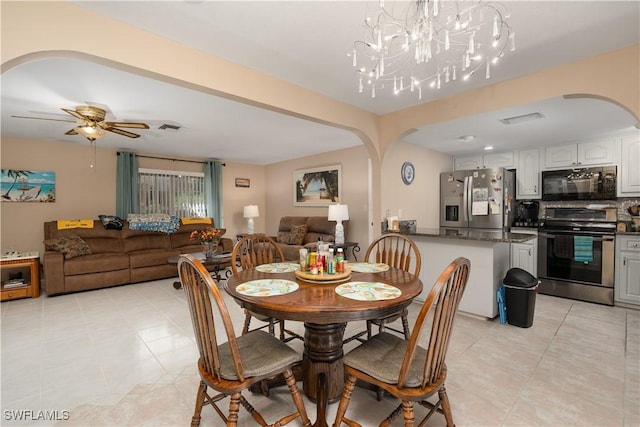 dining space with ceiling fan with notable chandelier