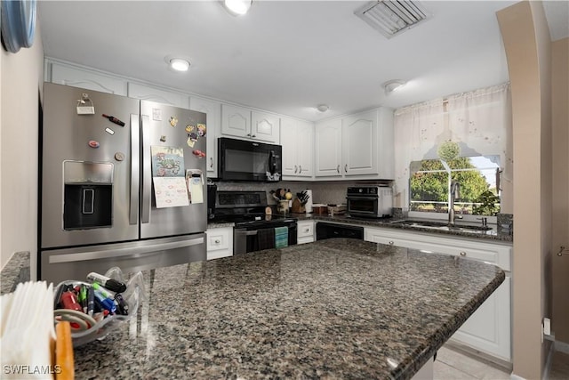 kitchen with white cabinets, dark stone countertops, and black appliances