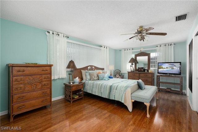 bedroom featuring ceiling fan, dark hardwood / wood-style flooring, and a textured ceiling