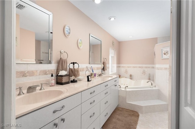 bathroom with vanity, tiled bath, and tile patterned floors