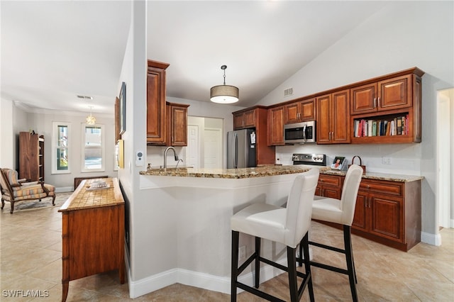 kitchen with light stone countertops, hanging light fixtures, sink, kitchen peninsula, and stainless steel appliances