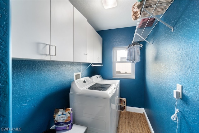 washroom featuring washer and clothes dryer, cabinets, and wood-type flooring