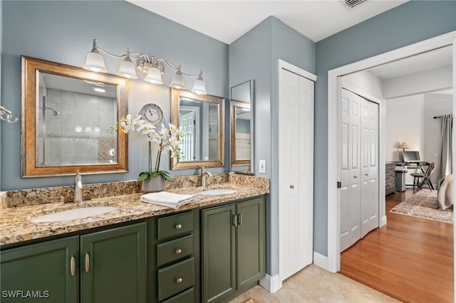 bathroom with tile patterned floors, vanity, and walk in shower