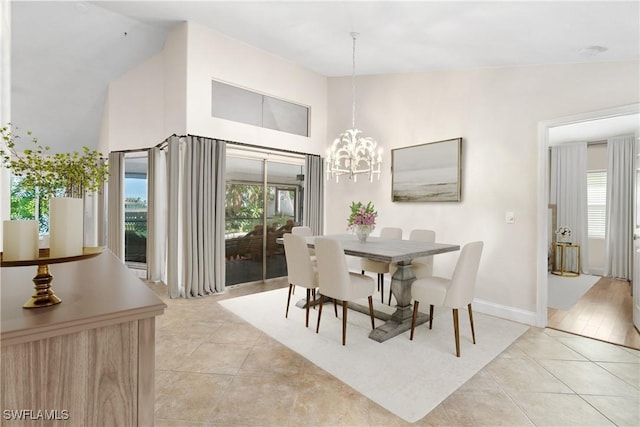 tiled dining space featuring lofted ceiling and a notable chandelier