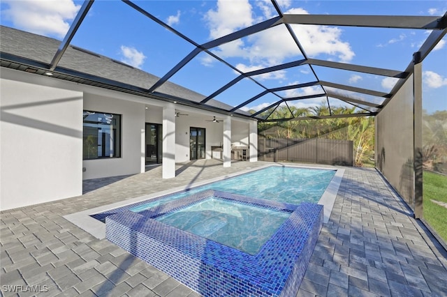 view of swimming pool featuring ceiling fan, a lanai, an in ground hot tub, and a patio