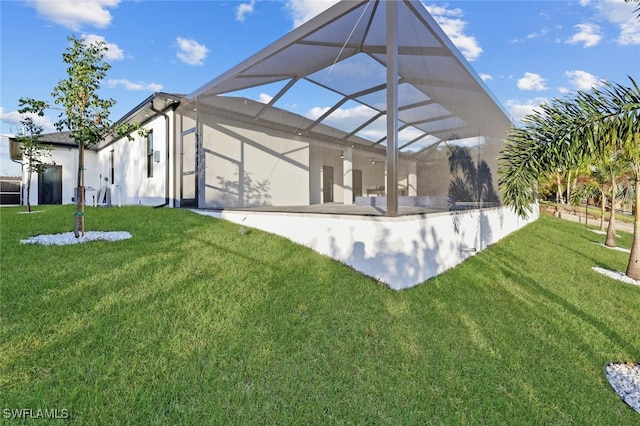 rear view of house featuring a lanai and a lawn