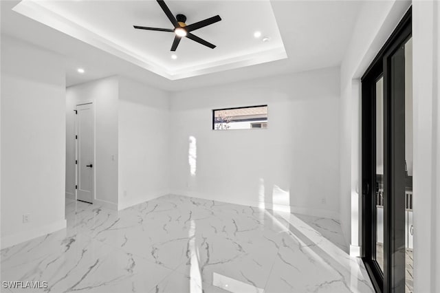 unfurnished room featuring a tray ceiling and ceiling fan