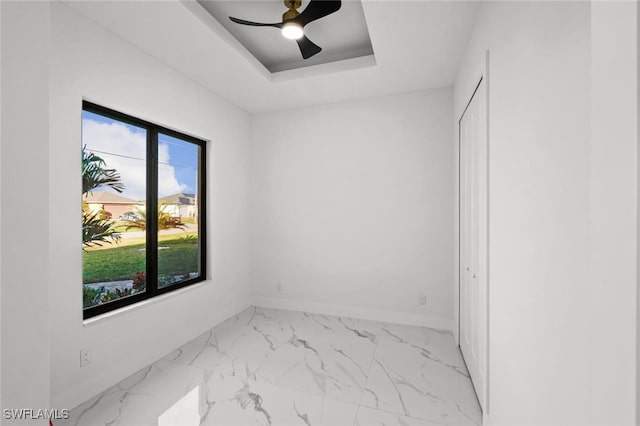 unfurnished room with a tray ceiling and ceiling fan