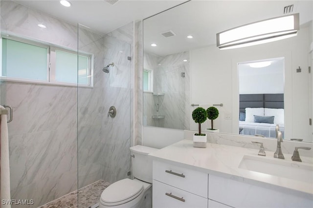 bathroom with a shower with door, vanity, and toilet