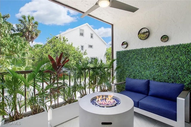 view of patio / terrace featuring ceiling fan and an outdoor living space with a fire pit