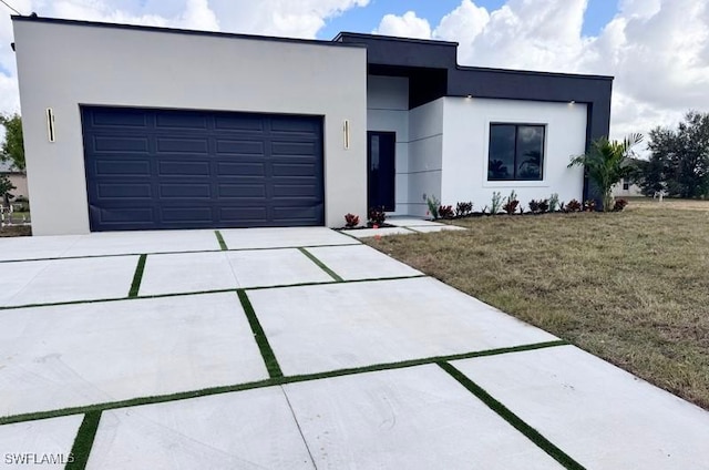 view of front of house featuring a garage and a front lawn