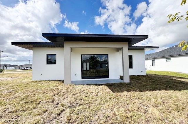 rear view of property with a lawn