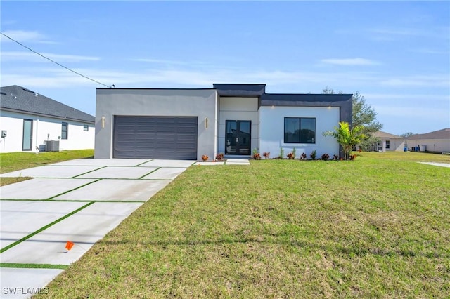 modern home with cooling unit, a garage, and a front yard