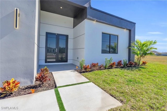 doorway to property with a yard and a patio