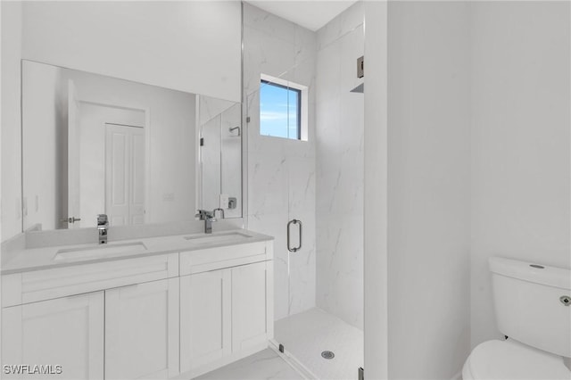 bathroom featuring a shower with door, vanity, and toilet